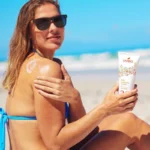 Une femme se passe de la crème solaire