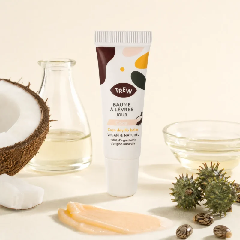 Tube baume à lèvres coco TREW posé près d'une noix de coco