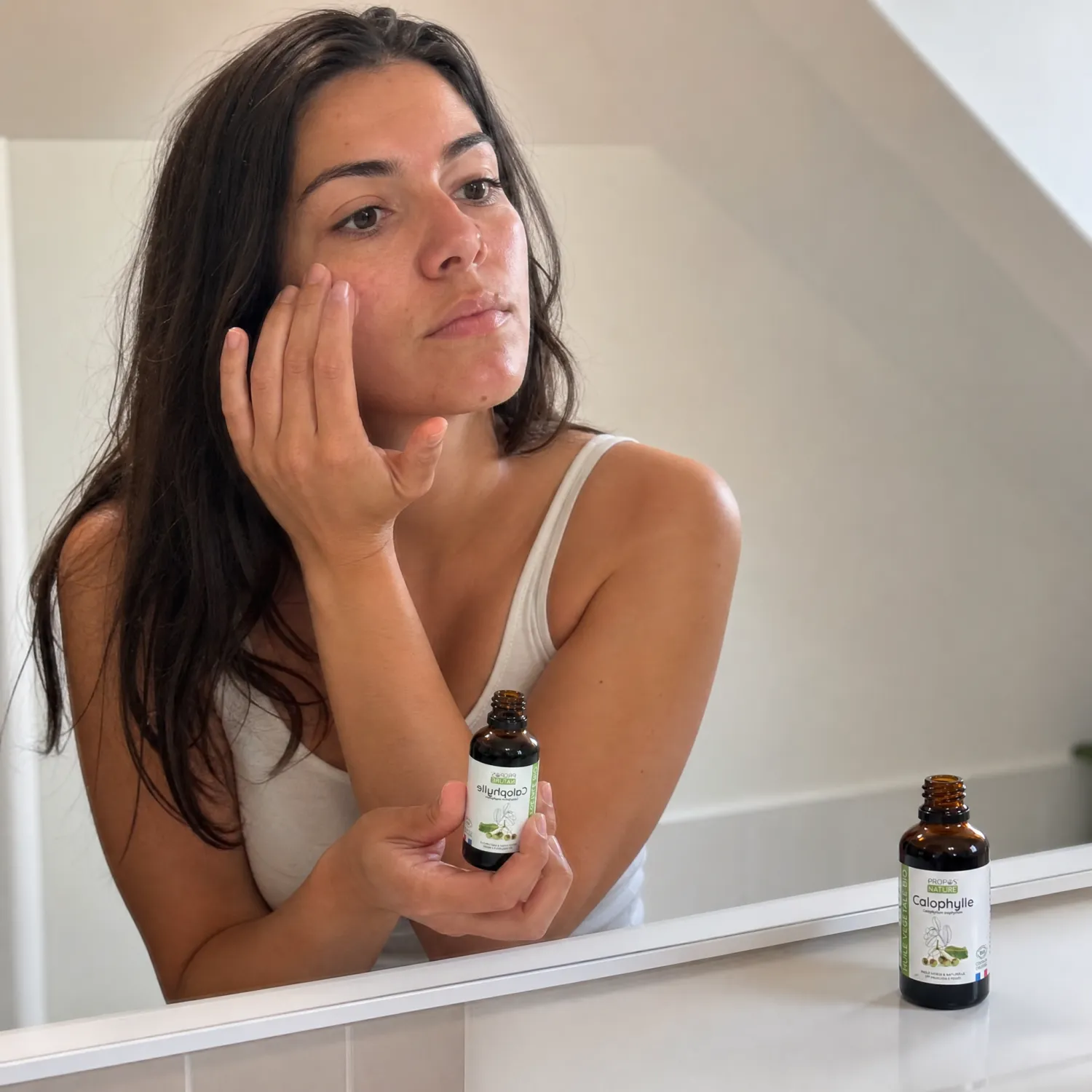 Femme appliquant l'huile de Calophylle Bio Propos'Nature sur le visage