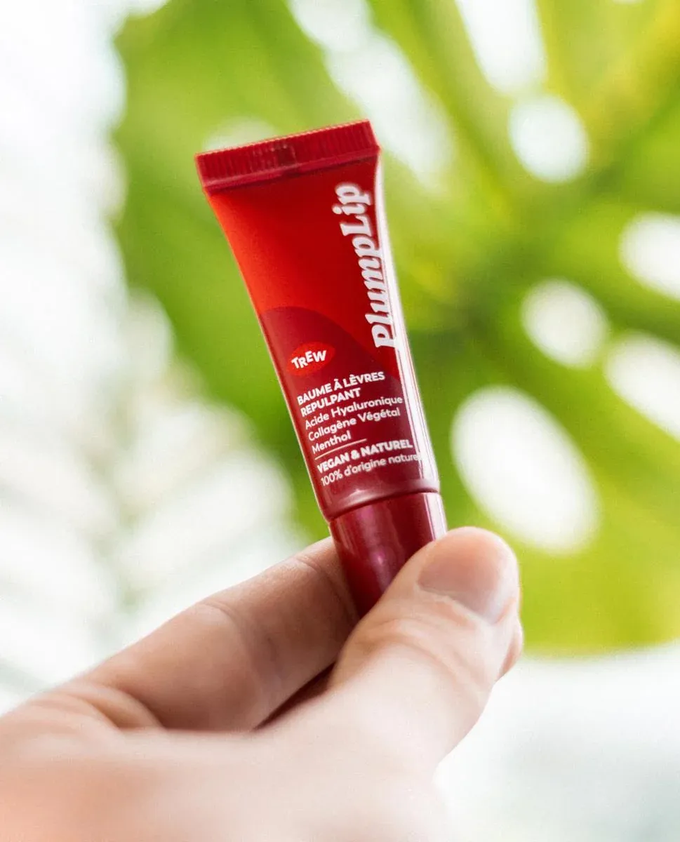 Tube rouge PlumpLip baume repulpant lèvres tenu à la main