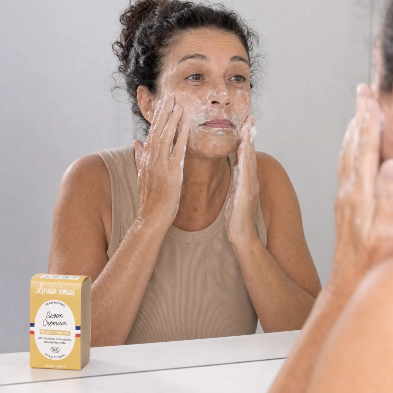 Femme mature appliquant le Savon Crémeux Bio Louise émoi sur son visage